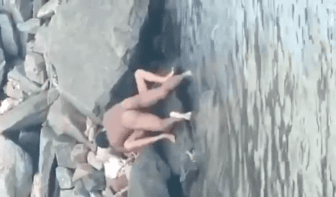 cogiendo a la orilla de la playa y los turistas los graban